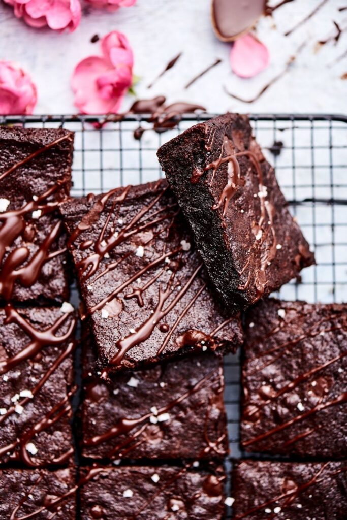 2 brownies stacked on top of one another and set next to other brownies.