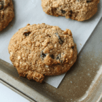 An oatmeal raisin cookie on a baking sheet