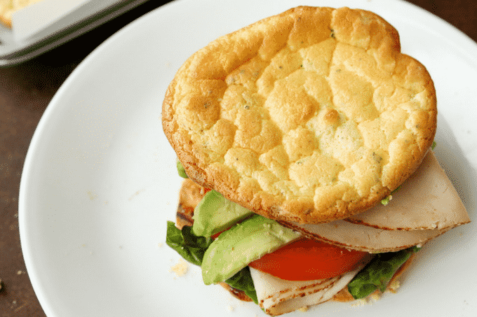 Carb free cloud bread being used as the bread for a turkey avocado and tomato sandwich.