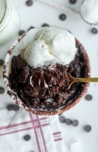 A chocolate mug cake with a piece about to be scooped out by a fork.