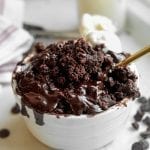 A Chocolate Lava Mug Cake sitting on a table with a fork inside of it.