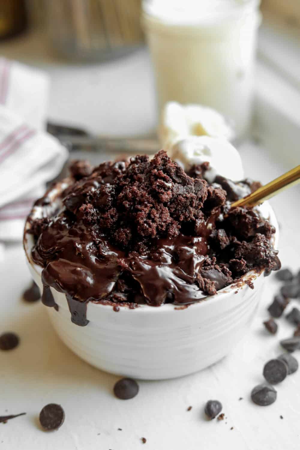 A Chocolate Lava Mug Cake sitting on a table with a fork inside of it.