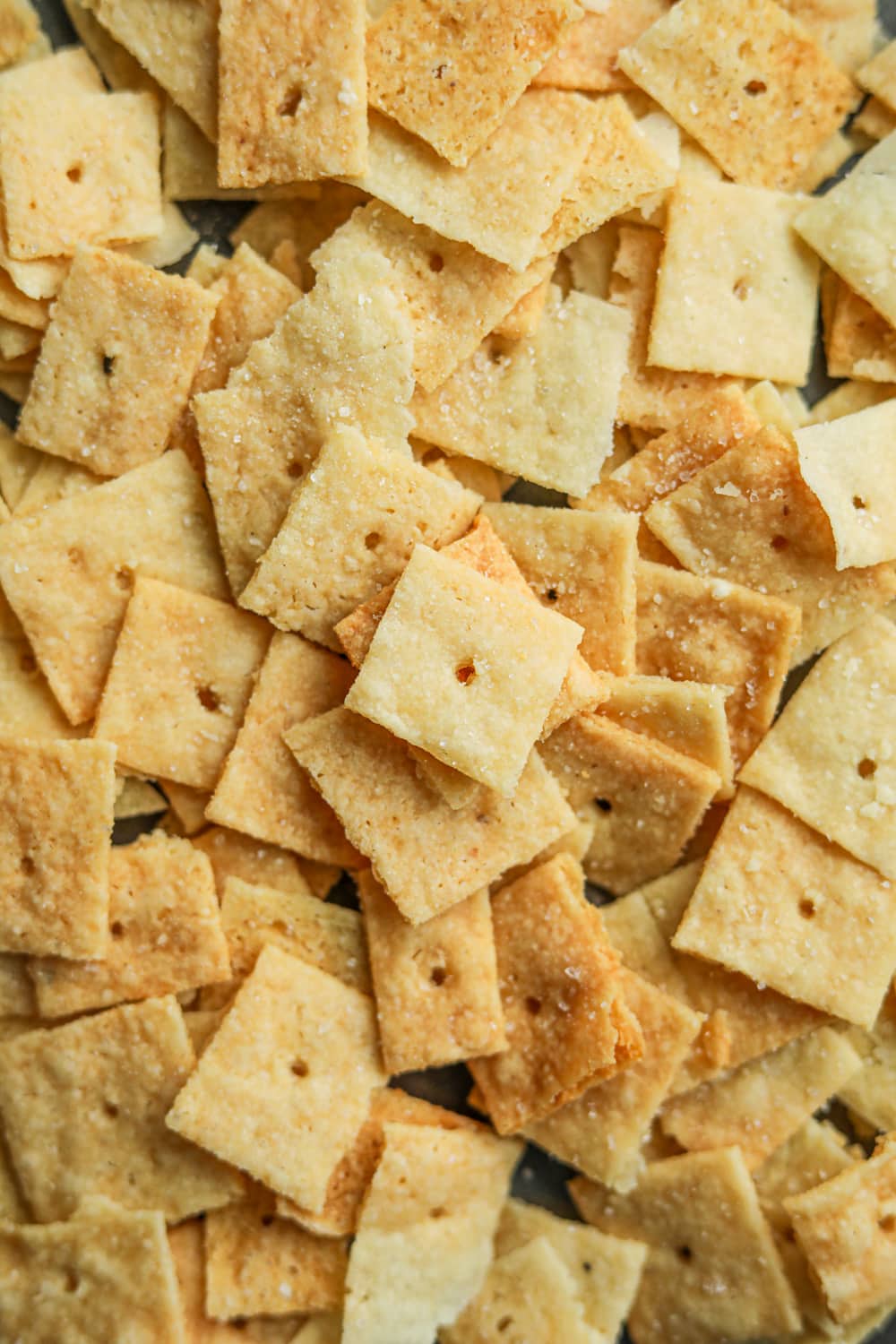 Cheese crackers laying on a baking sheet.