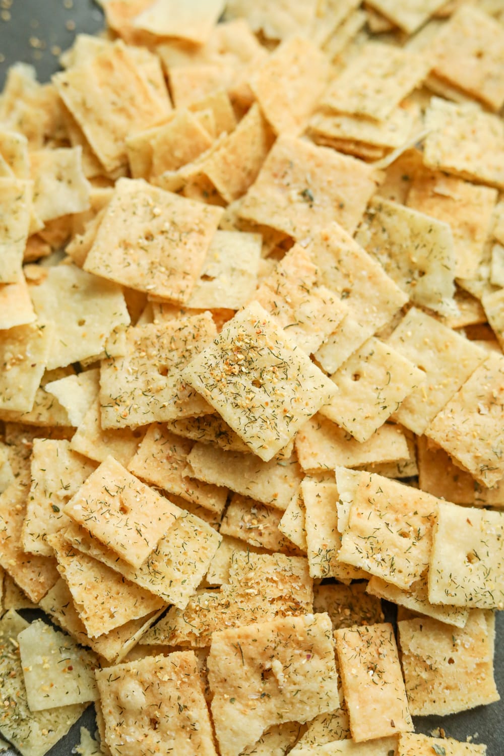 Lemon dill crackers laying on a baking sheet.