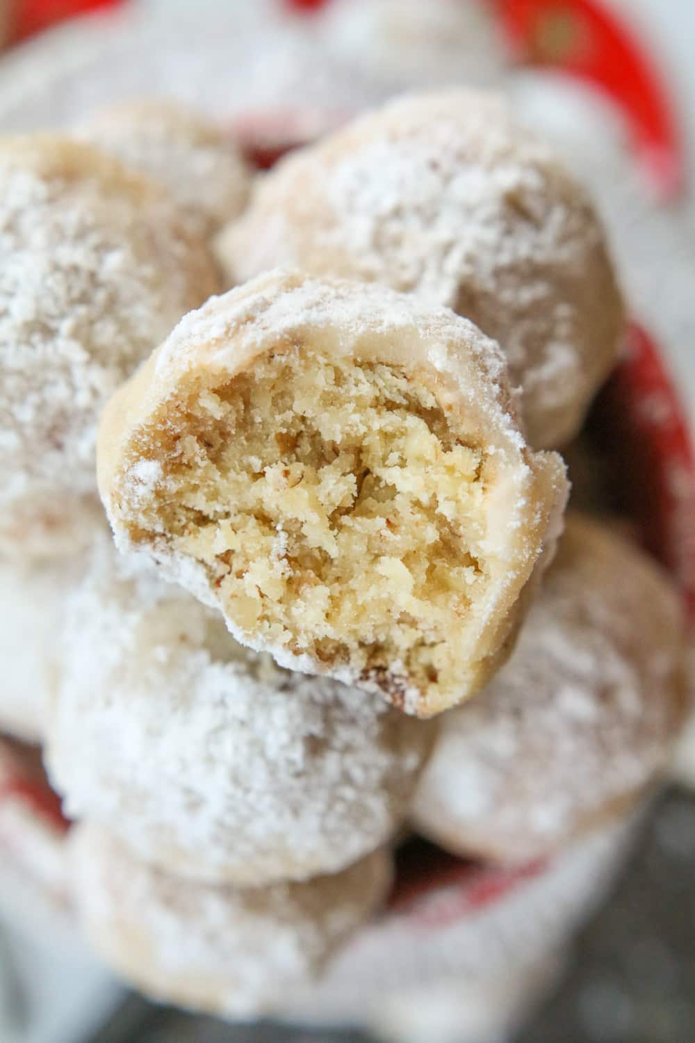 A snowball cookie with a bite taken out of it.