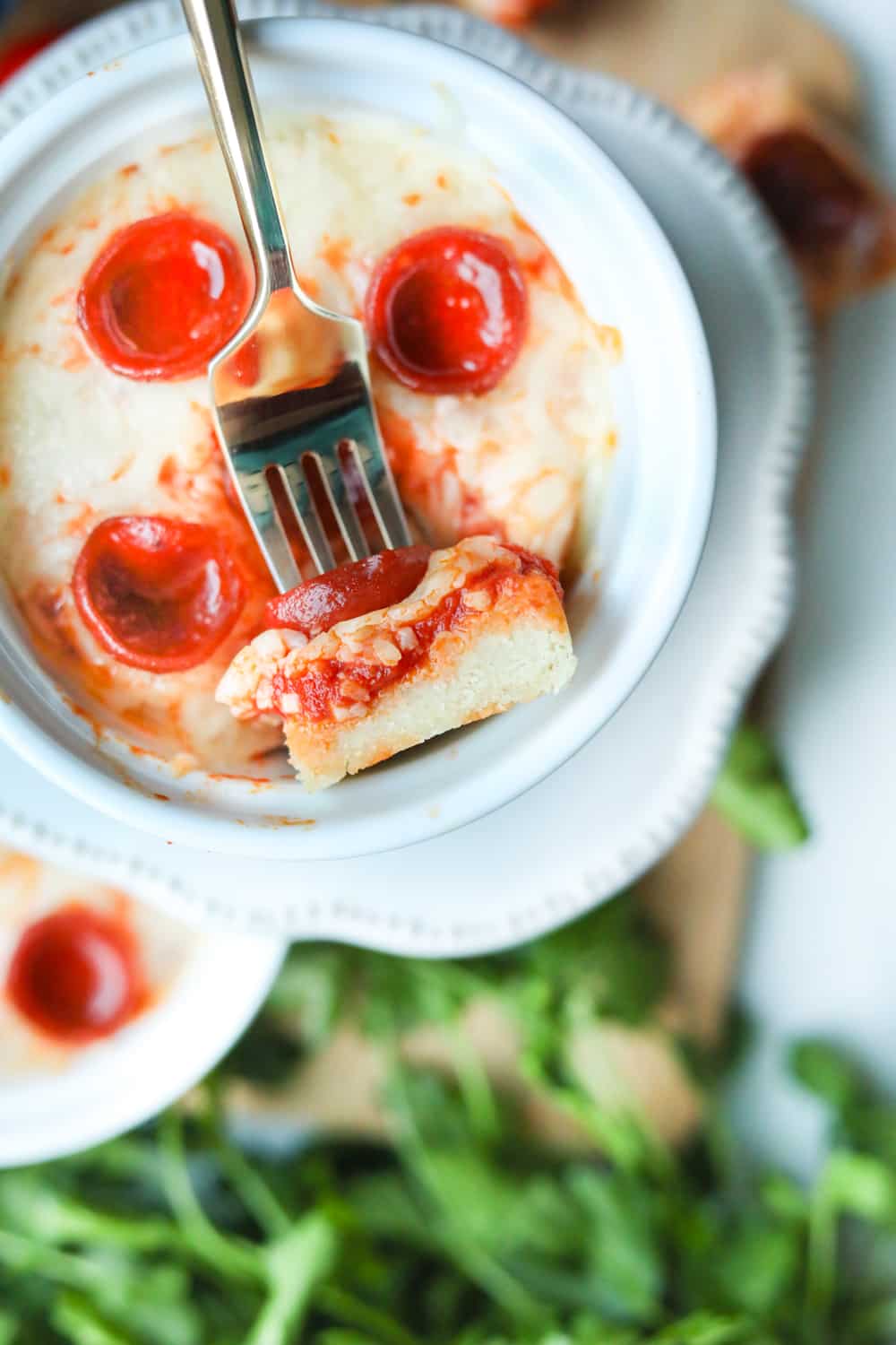 Pizza laying in a dish with a fork holding a piece