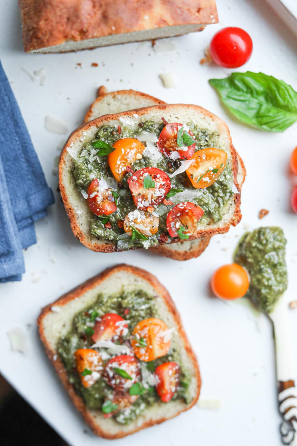 Slices of bread covered with pesto and tomatoes
