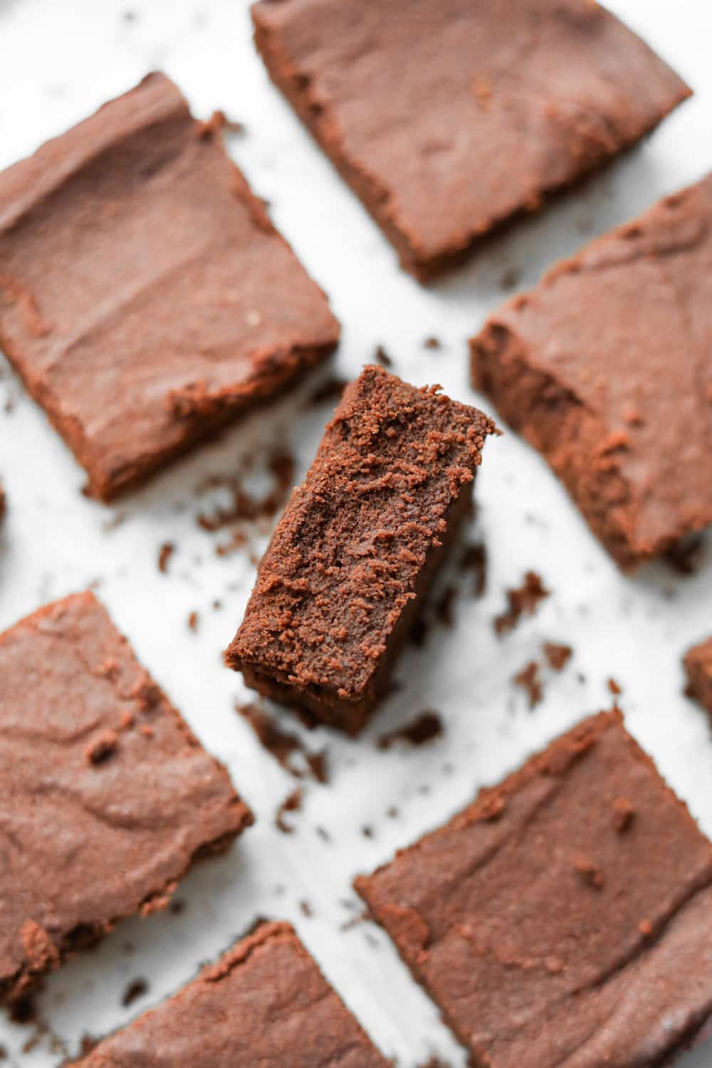 Keto brownies on a plate with the middle on inverted to show how fudgy it is.