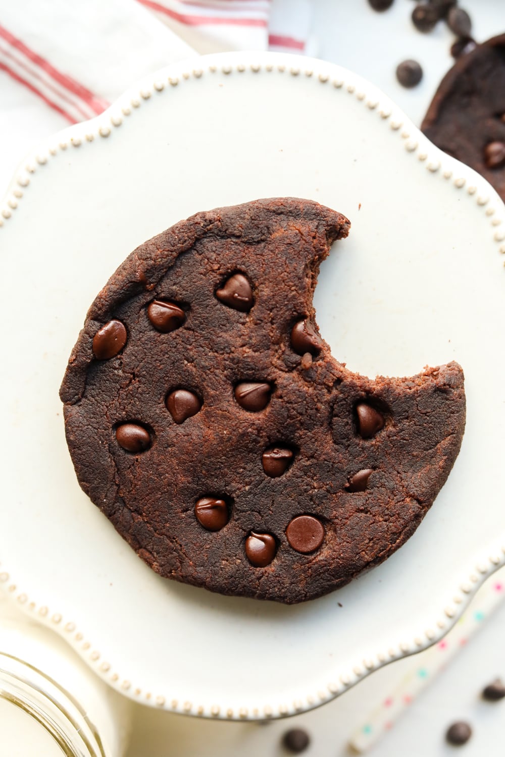 A double chocolate chip cookie with a bite taken out of it.