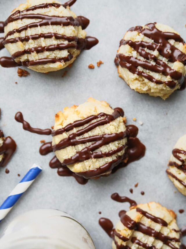 Keto butter cookies laying next to a glass of milk.