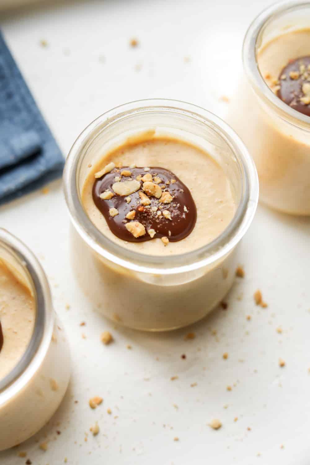 3 Jars of low carb peanut butter mousse covered with chocolate and peanuts.