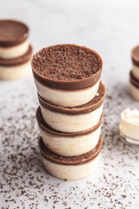 Cheesecake keto fat bombs stacked on top of one another.