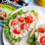 Open faced keto salmon sandwiches laying on a plate, and topped with cherry tomatoes.