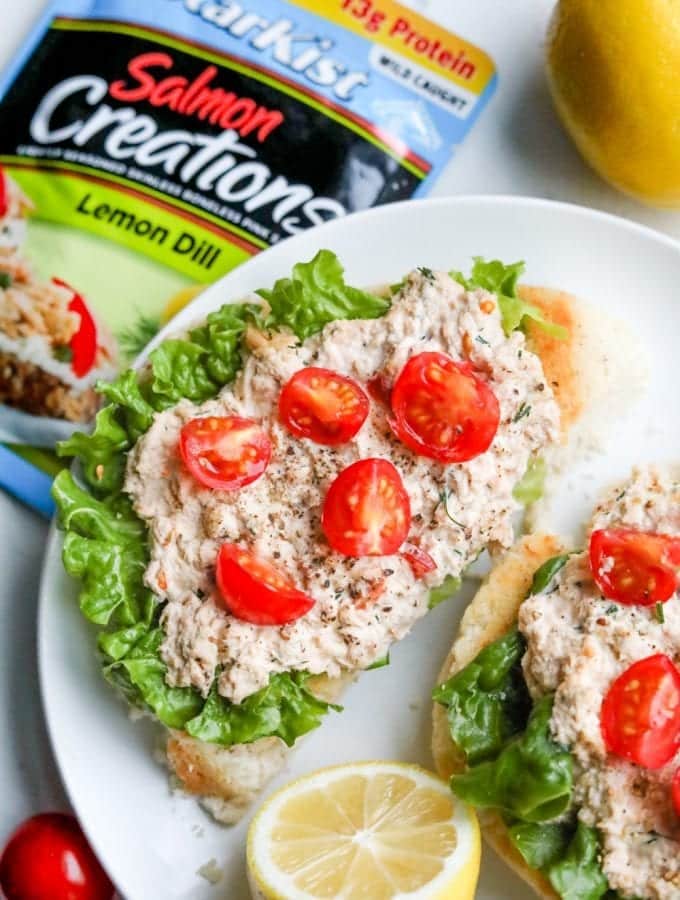 Open faced keto salmon sandwiches laying on a plate, and topped with cherry tomatoes.