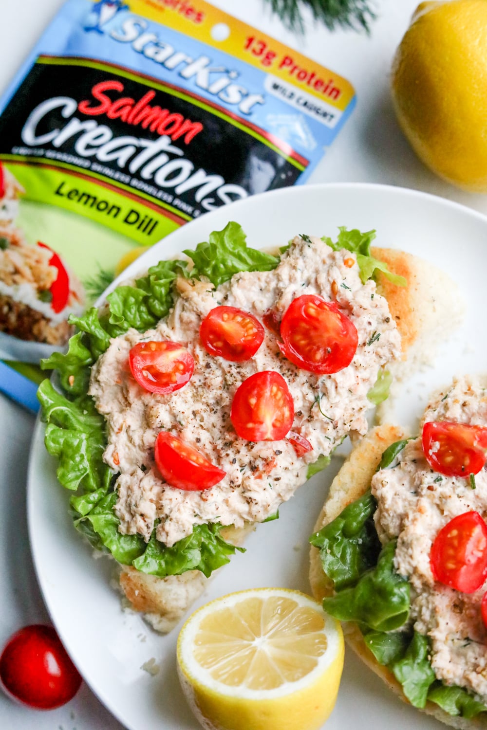 Open faced keto salmon sandwiches laying on a plate, and topped with cherry tomatoes.