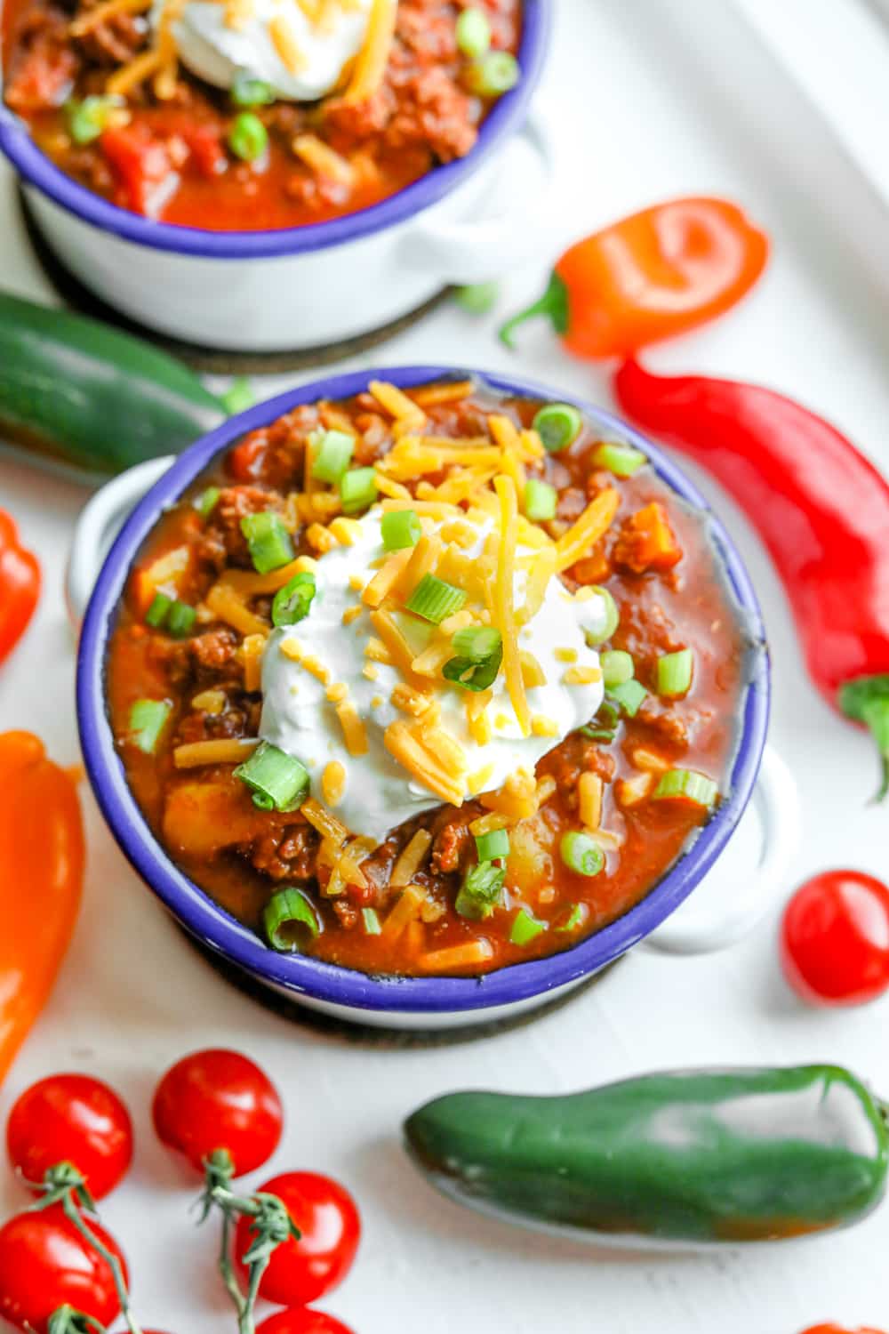 Low carb chili in a bowl topped with sour cream, cheese, and chives.