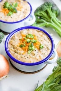 A bowl of keto broccoli cheese soup with another bowl of soup behind it.