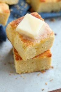 2 Thick slices of cornbread with melted butter on top.