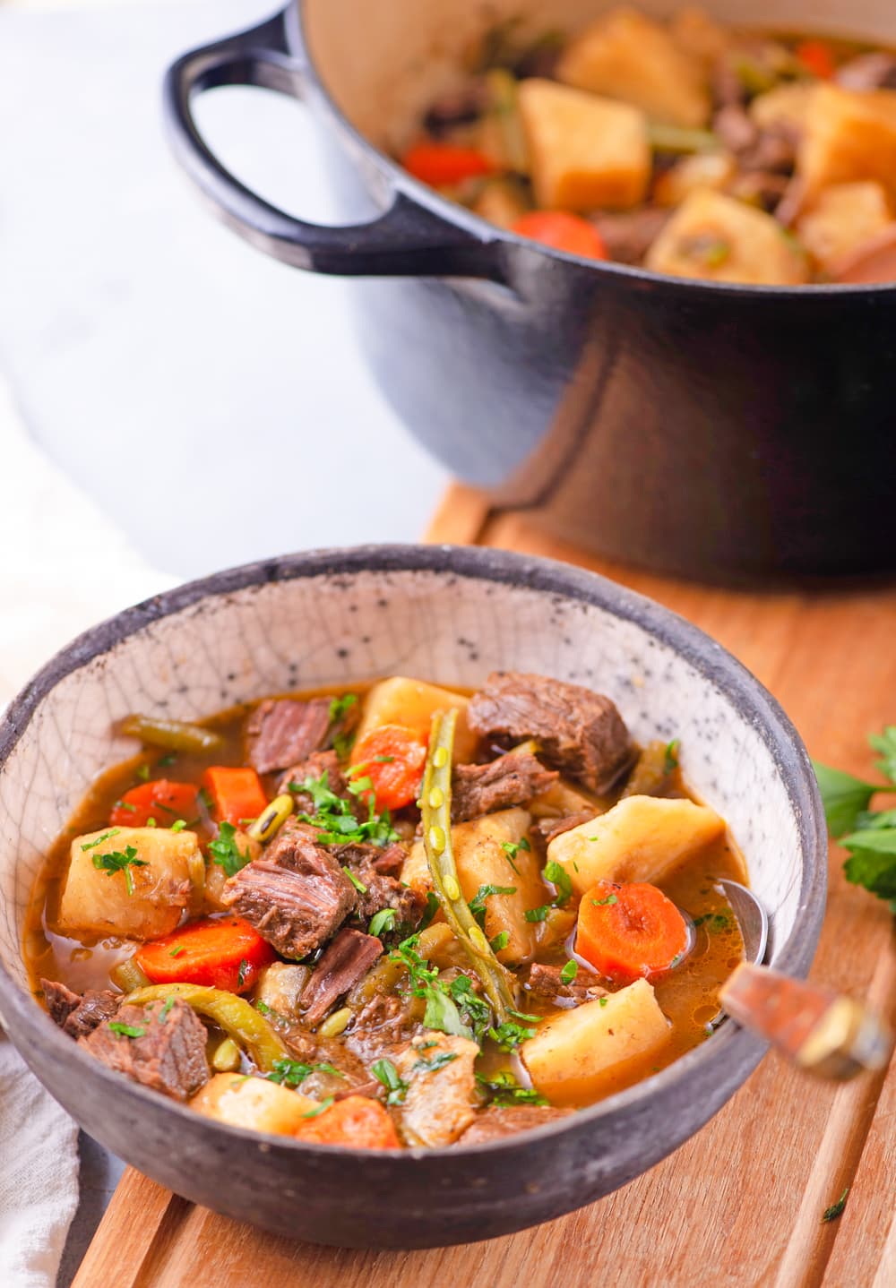 Keto beef stew in a bowl next to an entire pot of it.