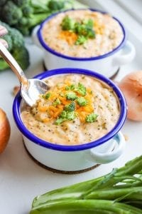 A spoon going into a bowl of keto broccoli cheese soup.