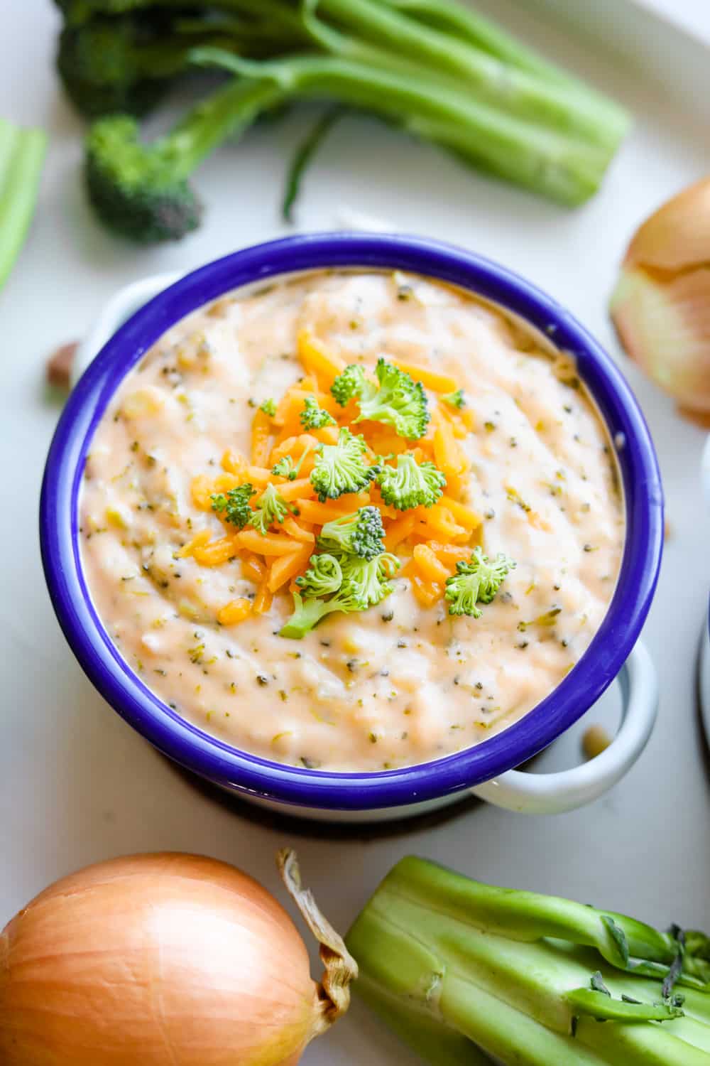 Low carb broccoli and cheese soup in a bowl topped with cheddar cheese.
