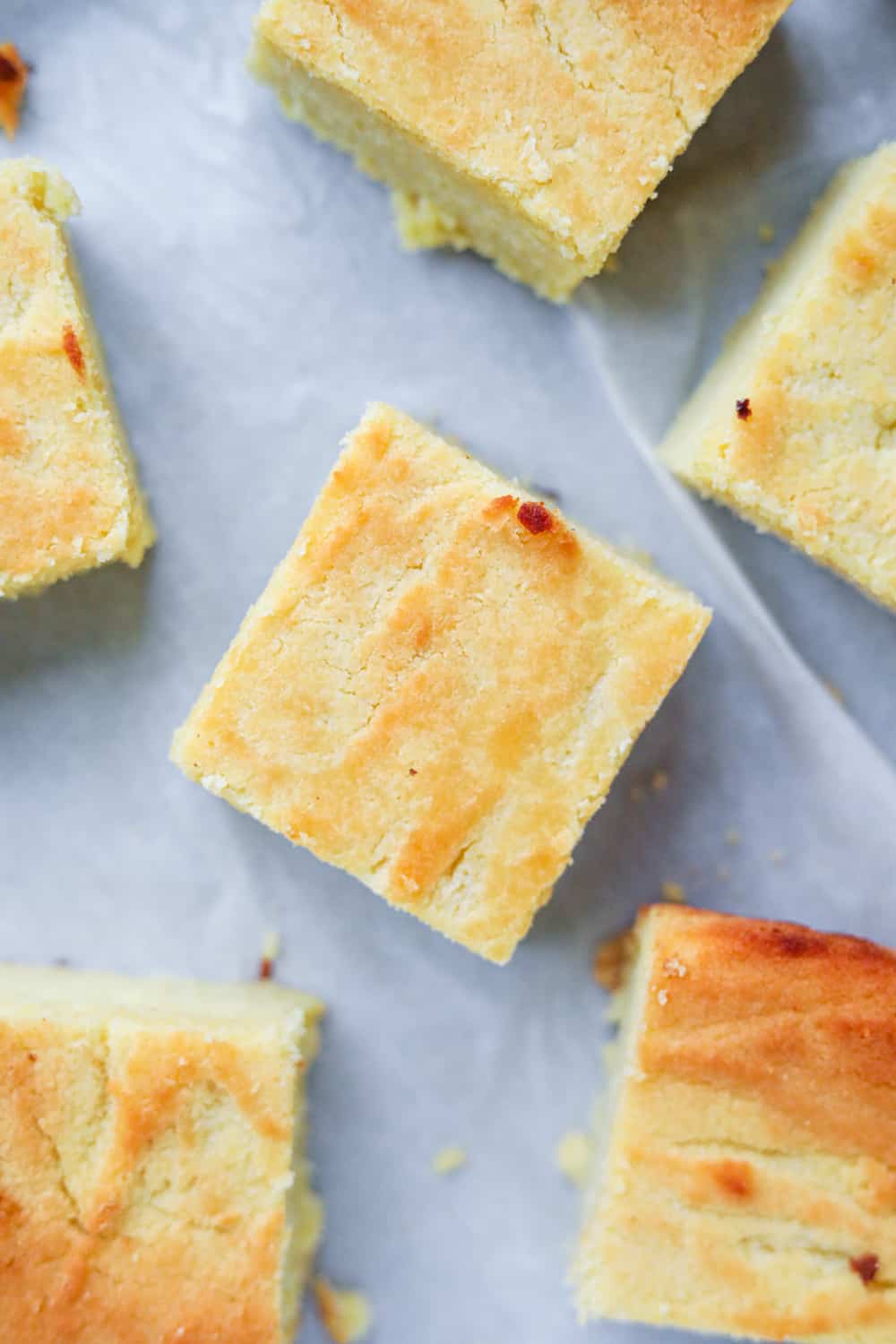 Keto cornbread cut up into slices on parchment paper.