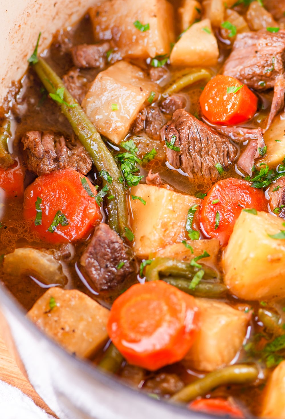 Chunks of beef, kohlrabi, and potatoes being cooked in a broth.