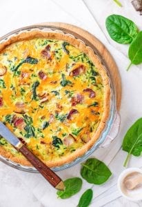 A bacon and spinach quiche set in a pie plate.