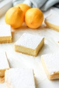 Lemon bars cut up on parchment paper.