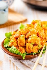 Orange Chicken in a bowl with chop sticks next to it.