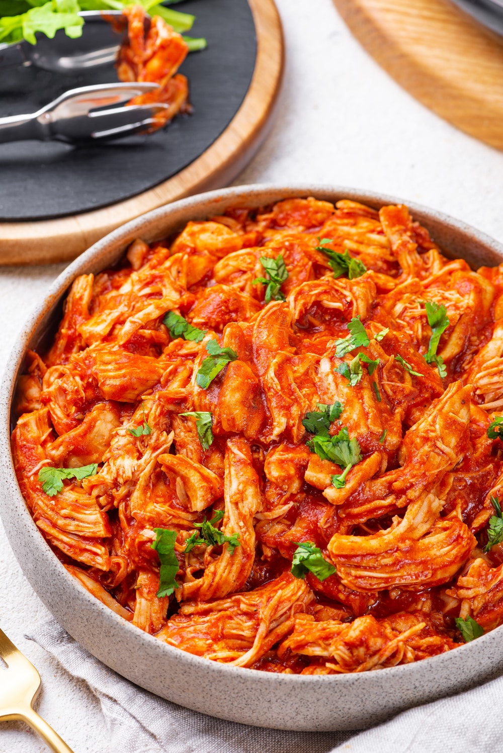 Shredded Chicken covered in low carb BBQ sauce and topped with fresh herbs.