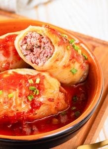 Cabbage rolls stacked on top of one another in a small dish.