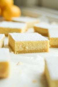 Lemon bars staggered on parchment paper.