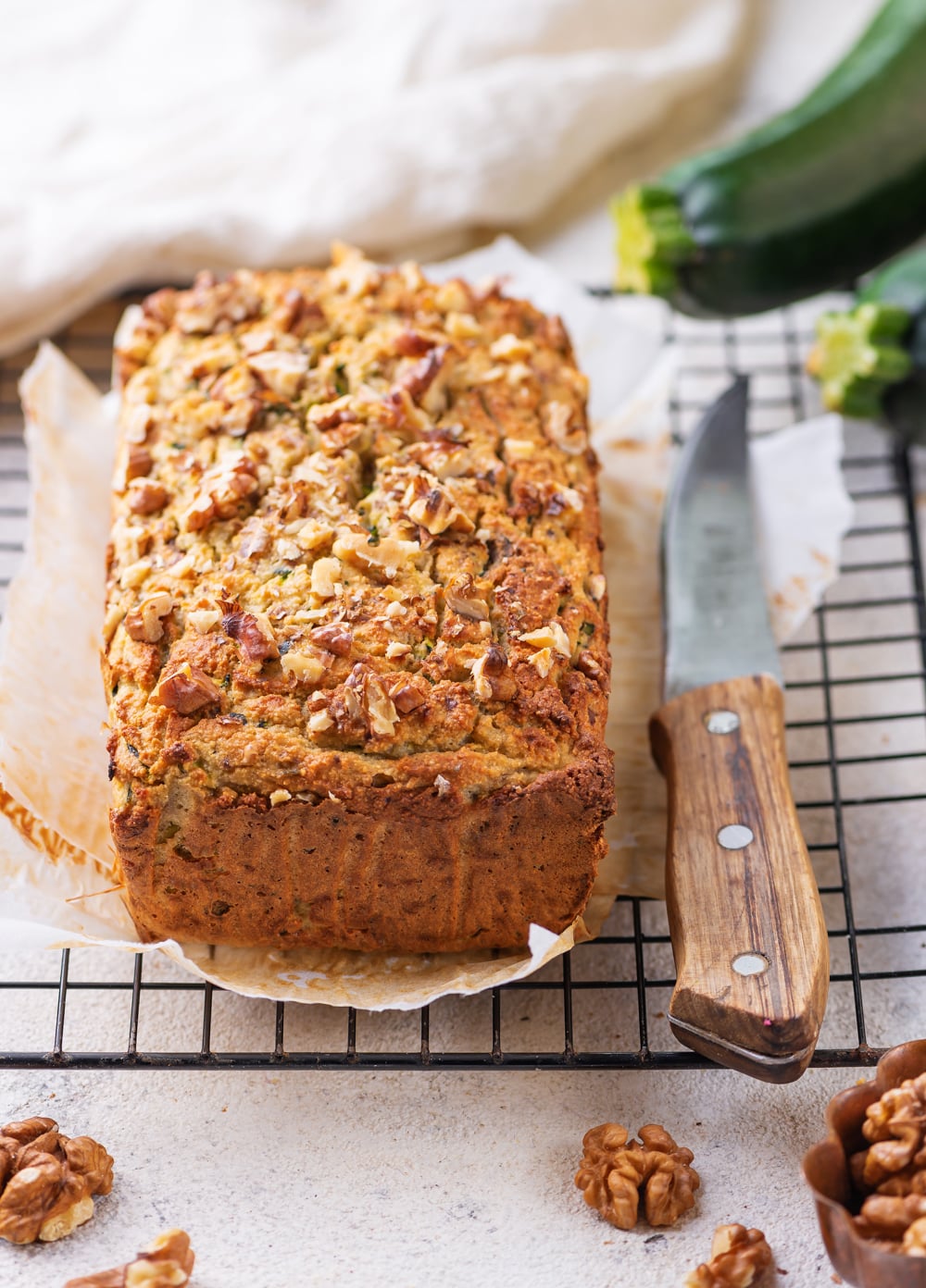 A whole loaf of zucchini bread on a drying rack.