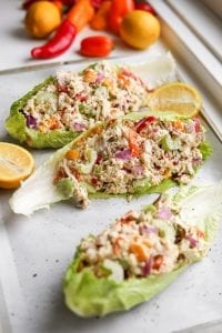 Lettuce wraps filled with chicken salad on a baking sheet.