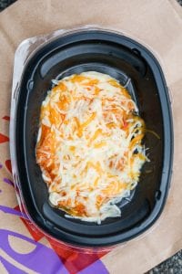 Shredded chicken covered in sauce and shredded cheese.