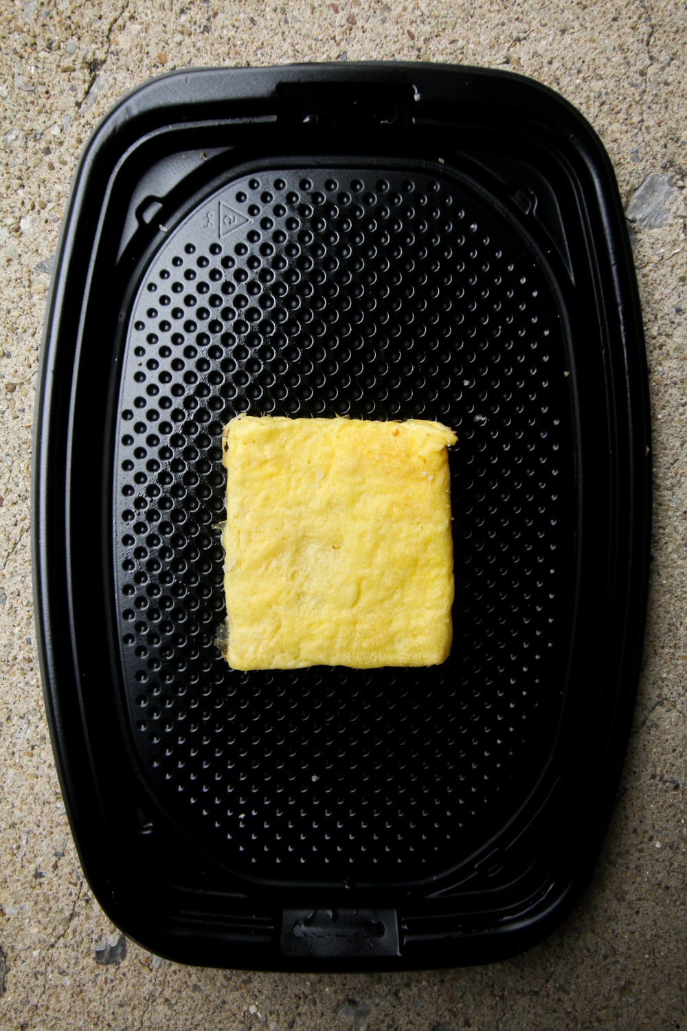 A fluffy egg on a black take-out container.