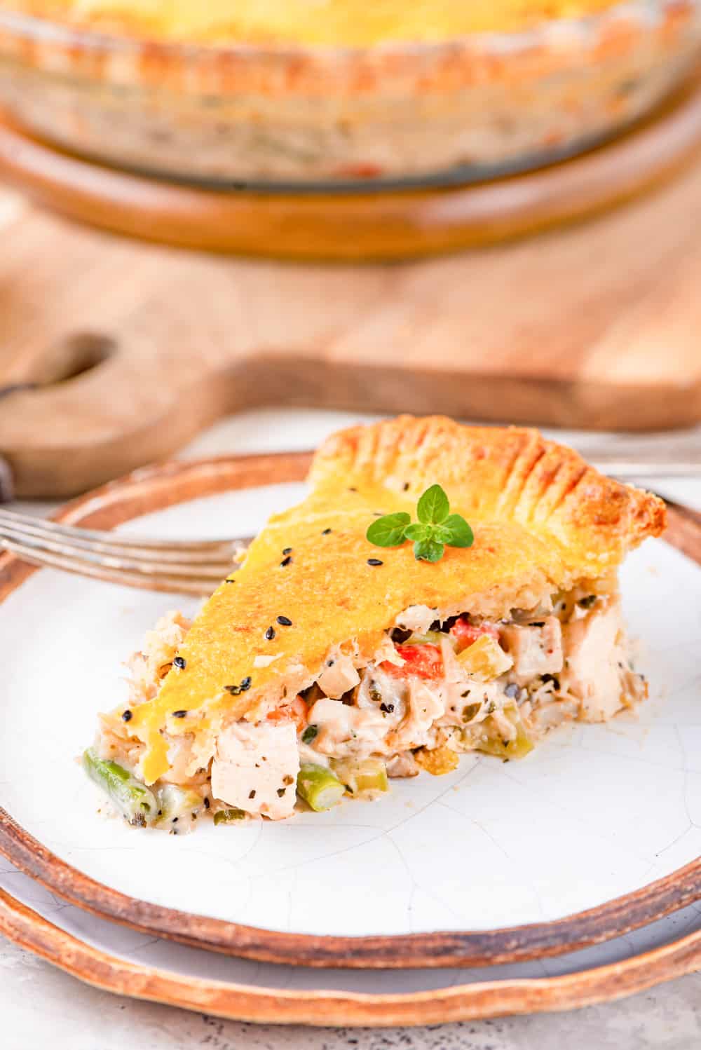 Chicken pot pie on a plate, and garnished with micro-greens.