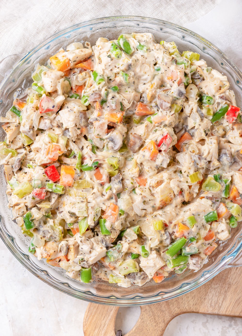 A bowl full of cooked vegetables, chicken, and cream cheese all mixed together.