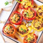 Bell peppers on baking sheet, cut in half, and filled with ground beef & cheddar cheese.