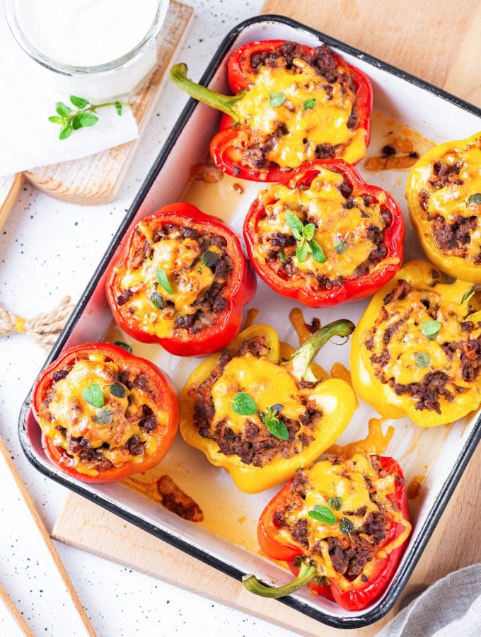 Bell peppers on baking sheet, cut in half, and filled with ground beef & cheddar cheese.