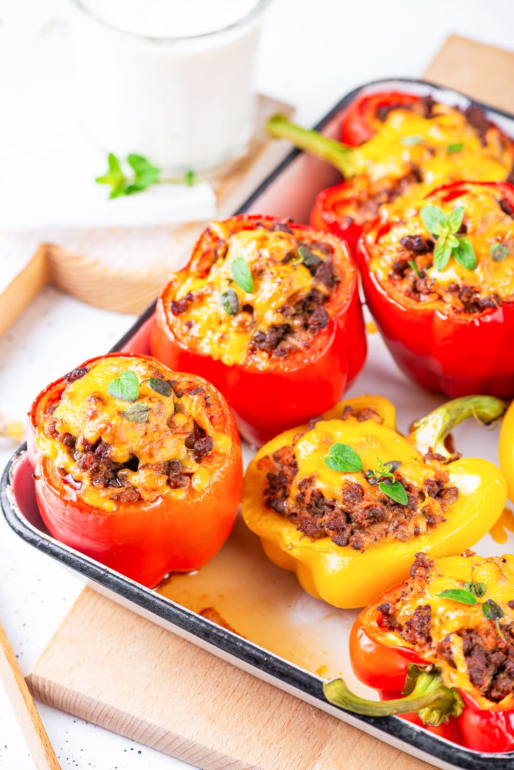 A mixture of whole stuffed bell peppers, and ones that have been cut in half and stuffed.