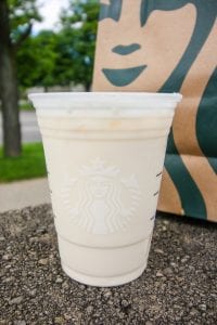 A white tea drink mixed with cream and sweetener in a cup.