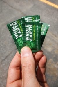 0 Carb sweetener packets being held by a hand.