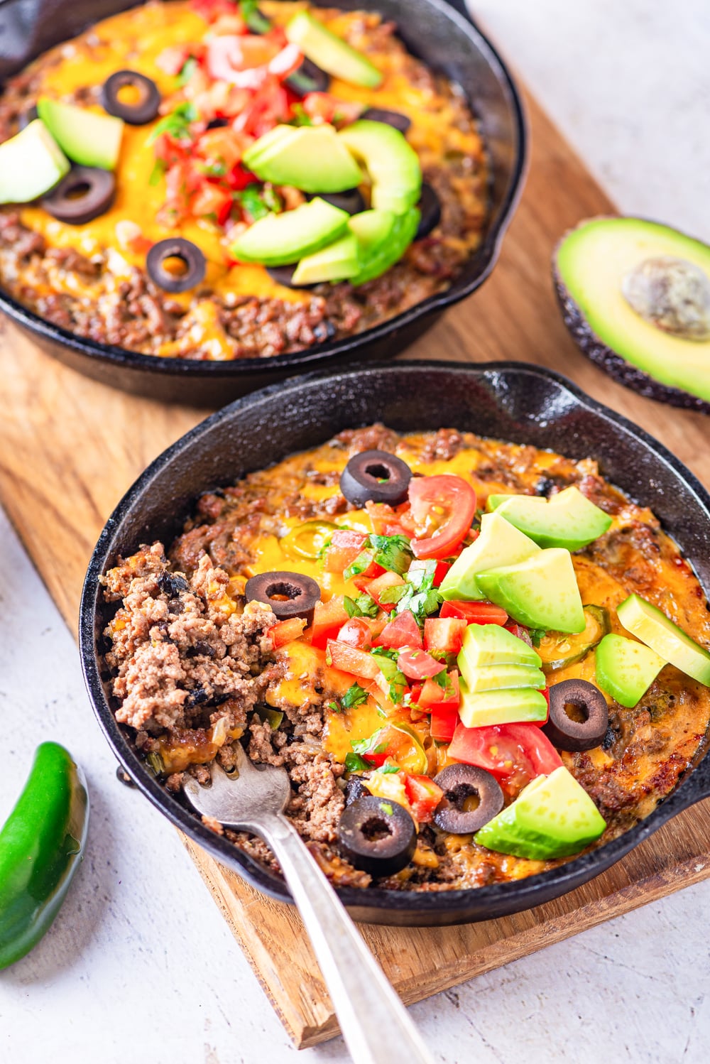 Ground beef, cheese, and black soybeans on a fork in a skillet.