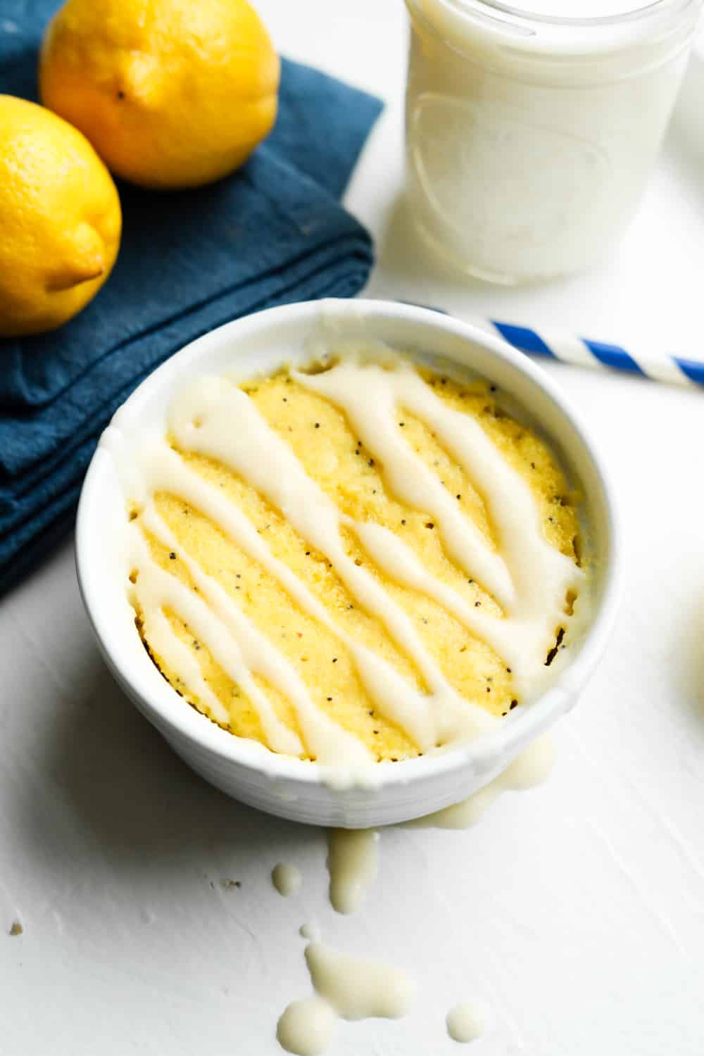 A lemon mug cake with a drizzle on top of it.