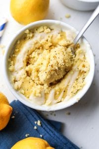 A lemon mug cake with a fork taking a piece out of the middle of the cake.