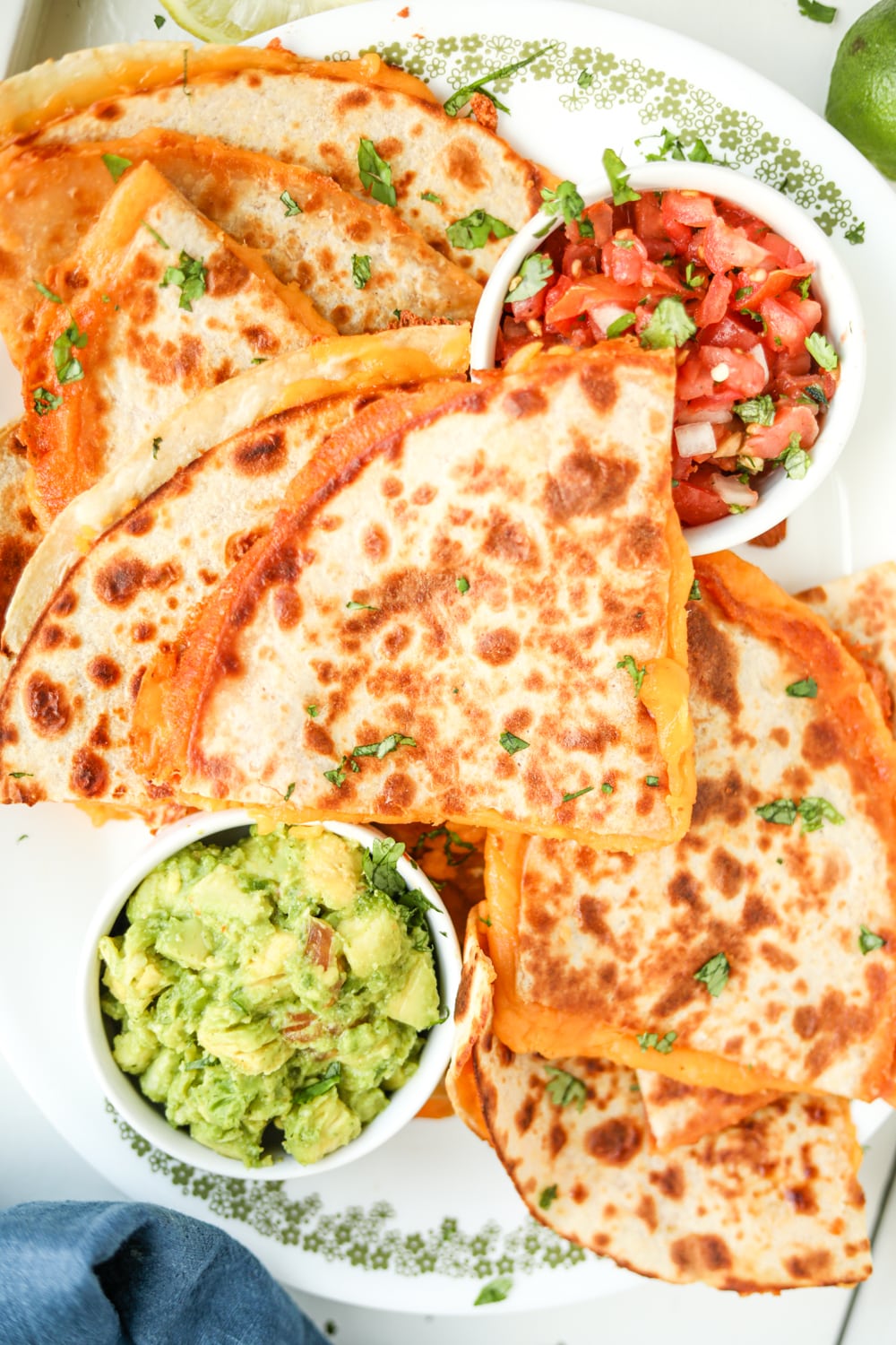 Cheese quesadillas on a white plate stacked on top of one another.