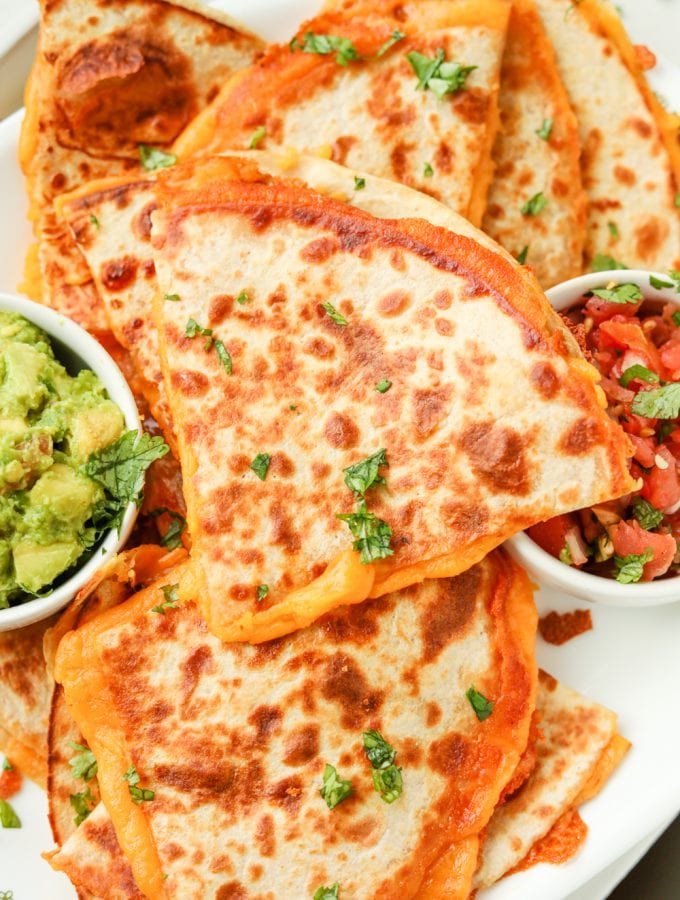 Quesadillas on a platter stacked on top of each other.