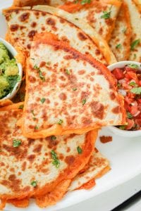 Quesadillas filled with cheddar cheese on a white plate.